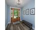 Stylish foyer with wood-look flooring, a wooden bench, and natural light from the glass paneled front door at 1375 Tannanger Trl, Awendaw, SC 29429
