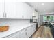 Modern kitchen featuring white cabinets, stainless steel appliances, and view to dining room and table at 1375 Tannanger Trl, Awendaw, SC 29429
