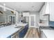Bright, open kitchen with stainless appliances, blue island with quartz countertops, and wood floors at 1375 Tannanger Trl, Awendaw, SC 29429