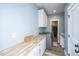 Well lit laundry room with modern appliances, light blue walls, wood countertops and closet access at 1375 Tannanger Trl, Awendaw, SC 29429