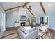 Bright living room featuring vaulted ceiling, wood beams, fireplace, and a comfortable gray sectional sofa at 1375 Tannanger Trl, Awendaw, SC 29429