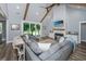 Open-concept living room with vaulted ceilings, wood beams, fireplace, and sliding doors to the backyard at 1375 Tannanger Trl, Awendaw, SC 29429