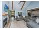 Cozy living room with fireplace, vaulted ceiling, exposed beams, open layout to kitchen and hardwood flooring at 1375 Tannanger Trl, Awendaw, SC 29429