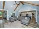 Spacious living room with exposed beams, open to the modern kitchen, and beautiful hardwood floors at 1375 Tannanger Trl, Awendaw, SC 29429