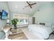 Bedroom featuring light green walls, wood ceiling fan, wood floors, a bed, and natural light from windows at 1375 Tannanger Trl, Awendaw, SC 29429