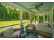 Inviting screened porch featuring comfortable wicker furniture and a serene backyard view at 1375 Tannanger Trl, Awendaw, SC 29429