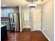 Dining area adjacent to the kitchen, boasting hardwood floors, gray walls, and stainless steel refrigerator at 1401 Dabbling Duck Dr, Summerville, SC 29483
