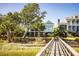 Beautiful coastal home with a charming pier leading to the front, nestled among lush greenery at 1410 Smythe St, Charleston, SC 29492