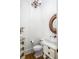 Charming powder room featuring a decorative mirror, wood floors, and paneled walls at 1410 Smythe St, Charleston, SC 29492