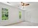 An empty bedroom featuring two windows, neutral walls and floors, a ceiling fan, and electric outlets at 143 Belleplaine Dr, Goose Creek, SC 29445