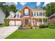 Classic two-story brick home with a welcoming front porch, manicured lawn and a two-car garage at 143 Belleplaine Dr, Goose Creek, SC 29445