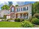Charming two-story home boasts a brick facade, inviting front porch, and lush landscaping at 143 Belleplaine Dr, Goose Creek, SC 29445