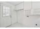 Bright laundry room features tile floor, cabinets, utility sink, and exterior access door at 143 Belleplaine Dr, Goose Creek, SC 29445