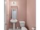 Powder room with a pedestal sink, a toilet, wall mirror and light fixture at 1533 Bluewater Way, Charleston, SC 29414
