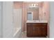 Well-lit bathroom features a dark wood vanity, a sink, and a tub with a white tiled wall surround at 1533 Bluewater Way, Charleston, SC 29414