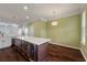 Kitchen island with wine fridge open to dining area with modern light fixture and view of the backyard at 1533 Bluewater Way, Charleston, SC 29414