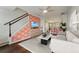 Open-concept living room with modern sofa, staircase, wood floors, and coral accent wall at 1533 Bluewater Way, Charleston, SC 29414