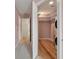 Hallway view of walk-in closet with hardwood flooring, shelves, and a stacked washer and dryer at 1533 Bluewater Way, Charleston, SC 29414