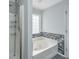 Bathroom featuring jetted tub with decorative tile and glass block window at 1582 Ocean Neighbors Blvd, Charleston, SC 29412