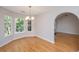 Dining area with hardwood floors, chandelier, and large windows, adjacent to an arched doorway at 1582 Ocean Neighbors Blvd, Charleston, SC 29412