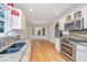 Bright kitchen with granite counters, stainless appliances, and hardwood floors adjoining an open dining area at 1582 Ocean Neighbors Blvd, Charleston, SC 29412