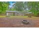 Spacious backyard featuring brick home exterior, fire pit, picnic table, and lush greenery at 206 Jimbo Rd, Summerville, SC 29485