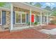 Inviting covered front porch with classic columns, black shutters, and a bright red front door at 206 Jimbo Rd, Summerville, SC 29485