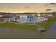 Aerial view showcasing a community pool with lounge area, cabanas, a wooden pier, and beautiful landscaping by the lake at 209 Celestial Blvd, Summerville, SC 29486