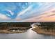 Stunning aerial view of a community set amidst tranquil lakes and surrounded by mature trees with beautiful sunset skies at 246 Calm Water Way, Summerville, SC 29486