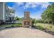 Exterior view of a backyard featuring a stone fireplace, patio, and green lawn at 246 Calm Water Way, Summerville, SC 29486