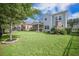 Spacious backyard featuring a lush lawn, screened porch, and an outdoor fireplace perfect for entertaining at 246 Calm Water Way, Summerville, SC 29486