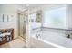 Relaxing bathroom featuring a soaking tub, separate shower and neutral-toned tiling at 246 Calm Water Way, Summerville, SC 29486