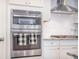 The kitchen features double ovens, white cabinets, granite countertops, and stainless steel appliances at 246 Calm Water Way, Summerville, SC 29486