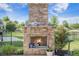 Outdoor brick fireplace with details, surrounded by a patio, manicured landscaping, and a fenced lawn at 246 Calm Water Way, Summerville, SC 29486