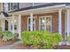 Townhome's brick porch with white columns, lush green bushes, and visible unit number at 302 Elm Hall Cir, Summerville, SC 29483