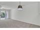 Bright, carpeted living room features sliding glass doors and a modern light fixture at 302 Elm Hall Cir, Summerville, SC 29483