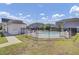 Community pool with fenced perimeter, lounge chairs, a bath house, and residences in background at 302 Elm Hall Cir, Summerville, SC 29483