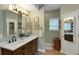 Bathroom showcasing dual sinks with white countertops, wood cabinets, and a well-lit vanity area at 3113 Edenvale Rd, Johns Island, SC 29455