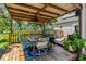 Charming covered patio with a dining table, chairs, and lush tropical plants at 3113 Edenvale Rd, Johns Island, SC 29455