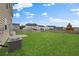 A spacious green backyard with a wooden fence and neighboring houses in the background at 320 Blue Shadows Ct, Summerville, SC 29486