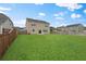 Well-maintained backyard featuring a green lawn, wooden fence, and a two-story house at 320 Blue Shadows Ct, Summerville, SC 29486