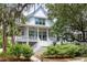 Charming two-story home featuring a welcoming front porch, white railings, and lush landscaping at 3305 Knot Aly, Johns Island, SC 29455