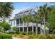 Beautiful two-story home featuring a screened porch, metal roof, and surrounded by tropical landscaping at 3305 Knot Aly, Johns Island, SC 29455