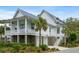 Stunning coastal home with a metal roof, inviting porch, ground level garage, and tropical landscaping at 3305 Knot Aly, Johns Island, SC 29455