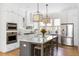 This kitchen boasts white cabinetry, stainless appliances, and an island with seating for casual dining at 3305 Knot Aly, Johns Island, SC 29455