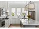 Bright kitchen features white cabinetry, stainless appliances, and large island with quartz countertops at 3305 Knot Aly, Johns Island, SC 29455