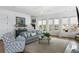 Bright living room with hardwood floors, shiplap walls, large windows, and comfortable seating at 3305 Knot Aly, Johns Island, SC 29455