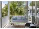Inviting front porch with a comfortable cushioned swing and palm trees in the background at 3305 Knot Aly, Johns Island, SC 29455