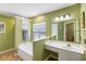 Bathroom featuring double sinks, soaking tub, a window, and bright green walls at 420 Manorwood Ln, Charleston, SC 29414