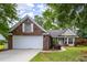 Brick home with a two-car garage, white shutters, and manicured landscaping at 420 Manorwood Ln, Charleston, SC 29414